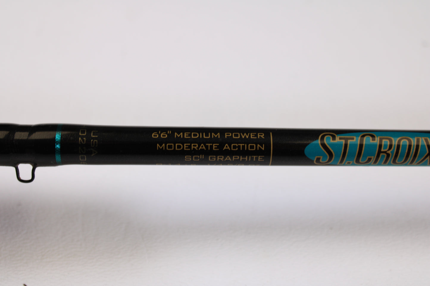 A close-up of a St. Croix Premier Crankbait PC66MM 6'6" Medium used casting rod in very good condition, showing its details on a black background with gold and teal accents—ideal for our Rod and Reel Trade-In Program.