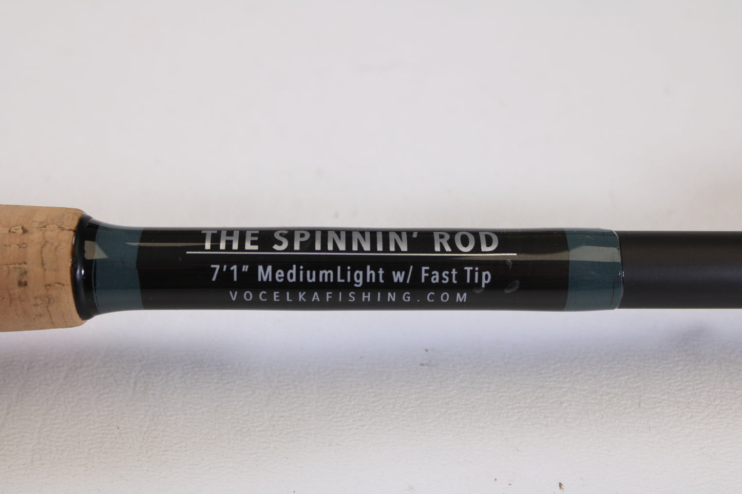Close-up of a Vocelka Tournament Series The Spinnin' Rod 7'1" Medium Light (Used, Excellent Condition) against a white background with part of the cork handle visible—ideal for our Rod and Reel Trade-In Program.