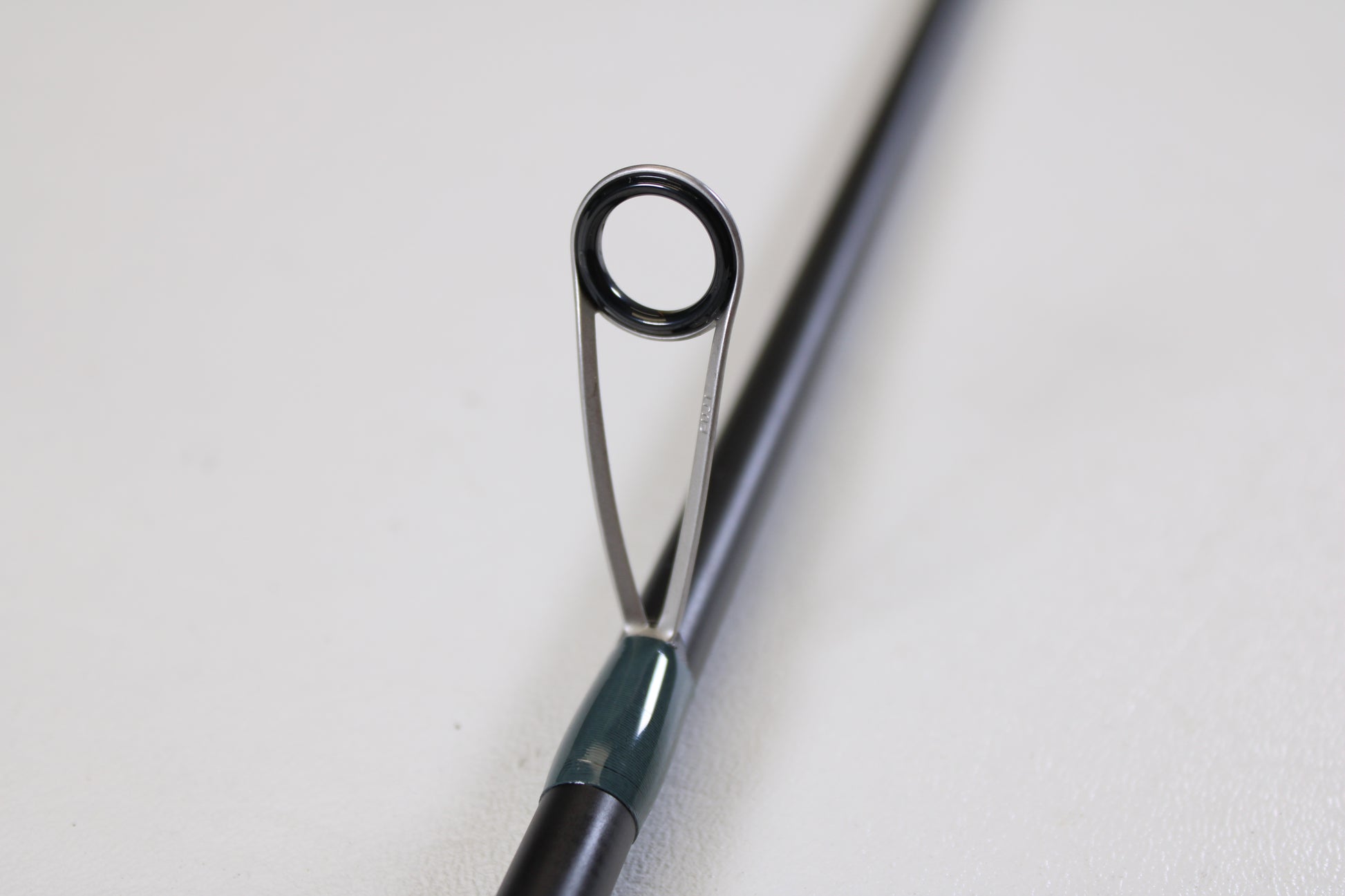 Close-up of the Vocelka Tournament Series The Spinn' Rod 7'1" Medium Light guide, showing its ring and support on a plain background. Ideal for those interested in trading or earning store credit with used Vocelka gear.