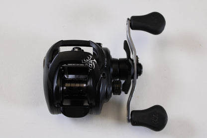 The Daiwa Tatula 150 TAT150P 5.5:1 RH - Used Casting Reel (Excellent Condition) is a black baitcasting reel with dual ergonomic handles and a silver crank—ideal for our Rod and Reel Trade-In Program if you're upgrading your gear.