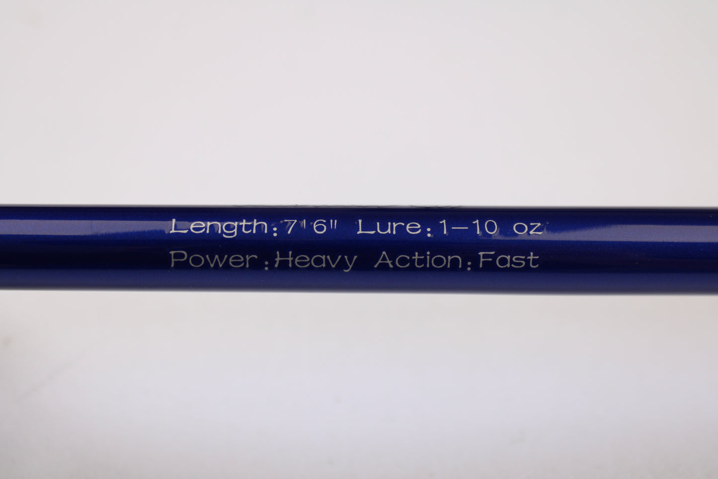 Close-up of a blue Shattered Cat 7'6" Heavy Used Casting Rod in excellent condition, showing white engraving: "Length: 7'6" Lure: 1–10 oz Power: Heavy Action: Fast." Ideal for trade-in or anyone seeking quality gear.