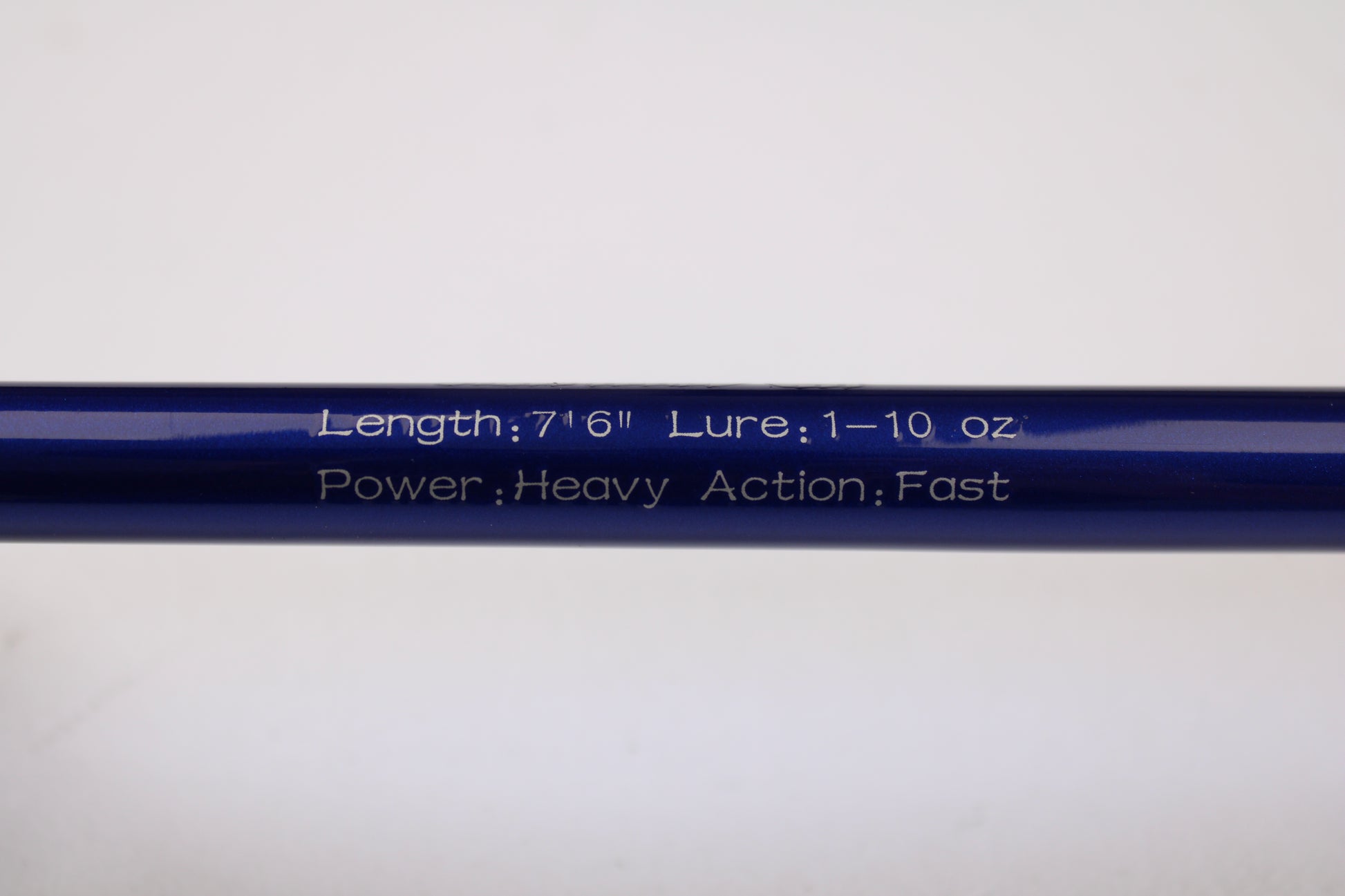 Close-up of a blue Shattered Cat 7'6" Heavy Used Casting Rod in excellent condition, showing white engraving: "Length: 7'6" Lure: 1–10 oz Power: Heavy Action: Fast." Ideal for trade-in or anyone seeking quality gear.