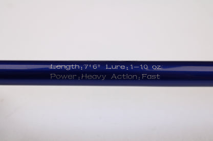 Close-up of a blue Shattered Cat 7'6" Heavy Used Casting Rod in excellent condition, showing white engraving: "Length: 7'6" Lure: 1–10 oz Power: Heavy Action: Fast." Ideal for trade-in or anyone seeking quality gear.