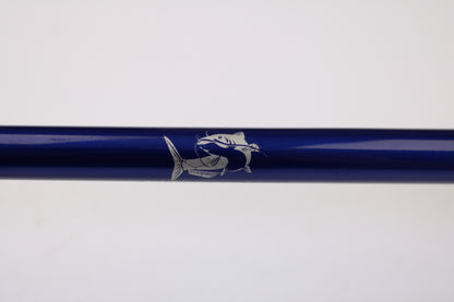 A close-up of the Shattered Cat 7'6" Heavy Used Casting Rod in excellent condition, featuring a white fish illustration on its blue surface—ideal for the Rod and Reel Trade-In Program or upgrading your gear.