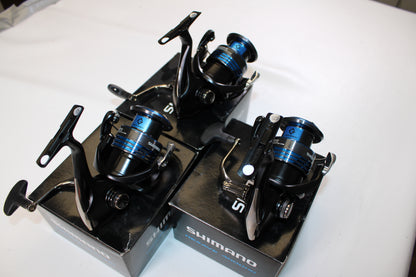 Three Shimano Nexave 4000HGFI spinning reels in mint condition are displayed atop their original boxes on a white surface.