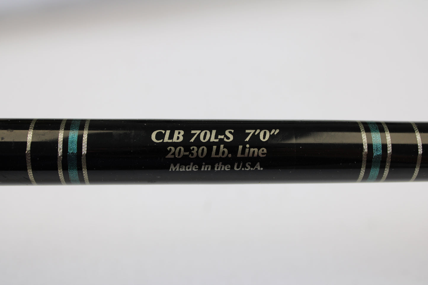 A close-up of a Cousins Tackle CLB 70L-S 7'0" used spinning rod (light, 20-30 lb line) in very good condition, showing “Made in the U.S.A.” text and blue/silver bands—possibly from our Trade-In program. Qty: 3.
