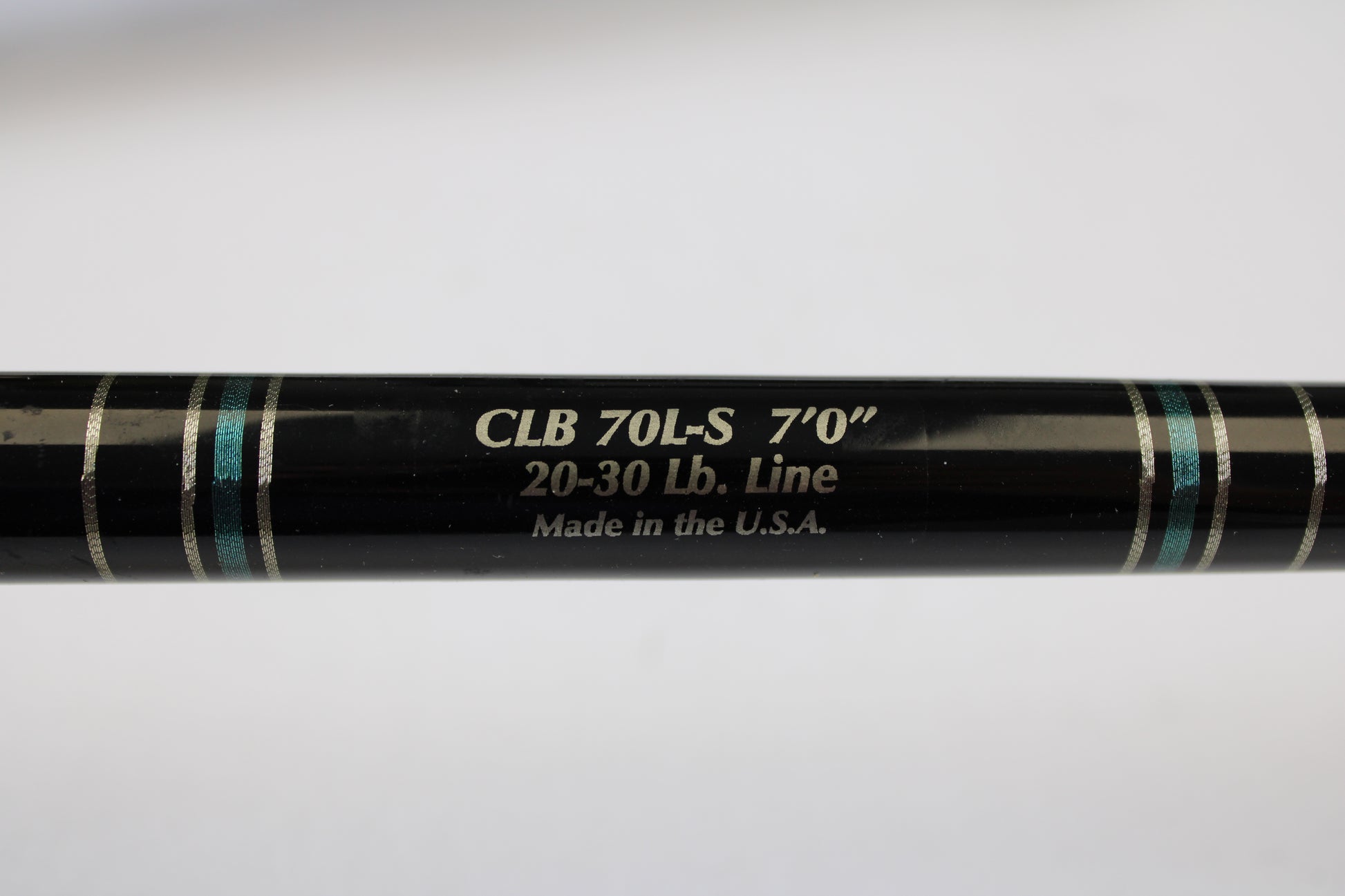 A close-up of a Cousins Tackle CLB 70L-S 7'0" used spinning rod (light, 20-30 lb line) in very good condition, showing “Made in the U.S.A.” text and blue/silver bands—possibly from our Trade-In program. Qty: 3.