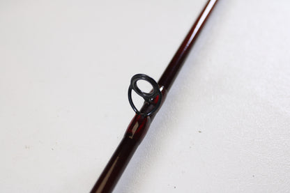 A close-up of the St. Croix Imperial I906.2 9'0" 6wt 2 Piece used fly rod in very good condition shows its dark metal guide on a brown rod—ideal for anglers seeking quality gear or exploring trade-in options, resting on a white textured surface.