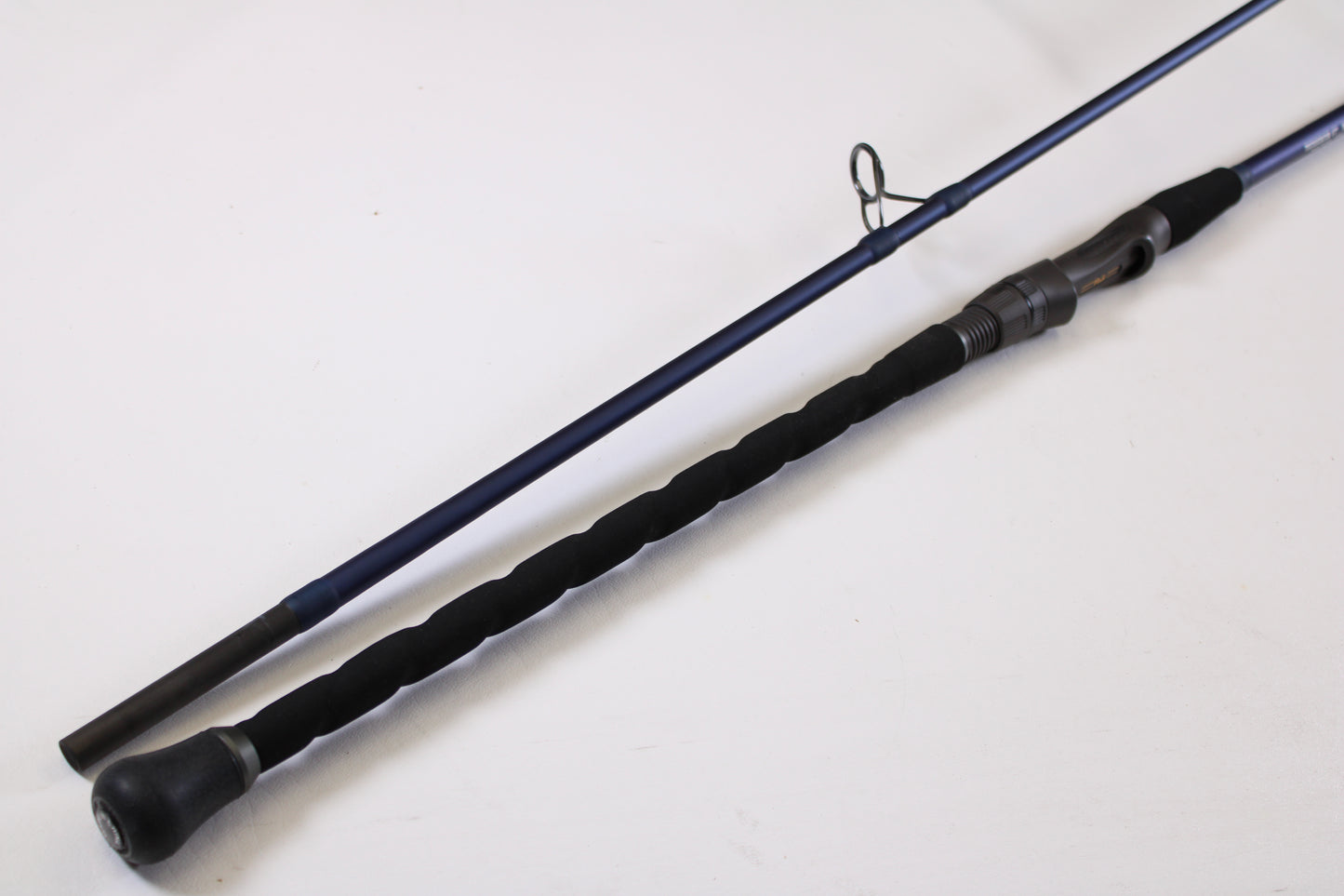 A close-up of the Tsunami SaltX Surf TSSTXIISS872M 8'7" Medium 2 Piece Used Spinning Rod—Excellent Condition—shows its black handle and reel seat, ideal for trading in through our Rod and Reel Trade-In Program for store credit.