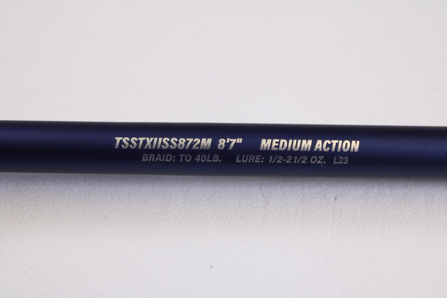 A close-up of a Tsunami SaltX Surf TSSTXIISS872M 8'7" Medium 2 Piece Used Spinning Rod in excellent condition—ideal for the Rod and Reel Trade-In Program and earning store credit.