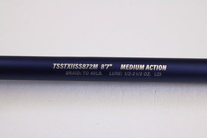 A close-up of a Tsunami SaltX Surf TSSTXIISS872M 8'7" Medium 2 Piece Used Spinning Rod in excellent condition—ideal for the Rod and Reel Trade-In Program and earning store credit.