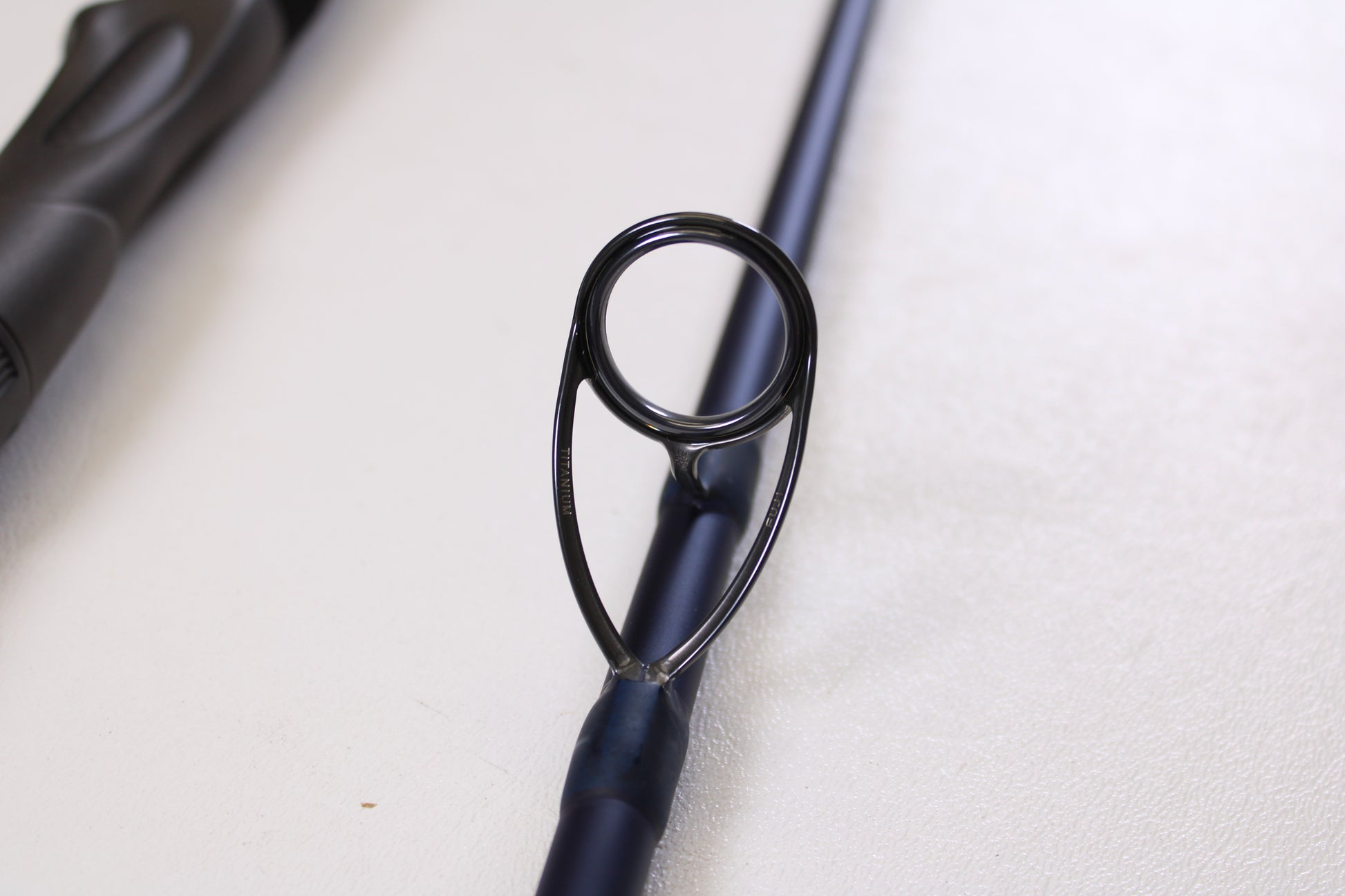 Close-up of the circular metal guide ring on a Tsunami SaltX Surf TSSTXIISS872M 8'7" Medium 2-Piece Spinning Rod (Used, Excellent Condition) by Tsunami—ideal for upgrade through our Rod and Reel Trade-In Program.