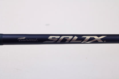 A close-up of the Tsunami SaltX Surf TSSTXIISS771M 7'7" Medium Used Spinning Rod in excellent condition, featuring the "Tsunami SALTX" logo on a dark blue finish—ideal for those exploring our Trade-In Program or quality used gear.