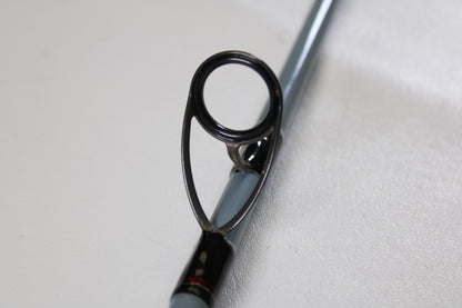 Close-up of a Daiwa Team Daiwa Surf TDSF1062MHFS 10'6" Medium Heavy 2 Piece Spinning Rod guide, showing the metal loop for directing line. Used rod in very good condition—eligible for our Rod and Reel Trade-In Program. Plain, light background.