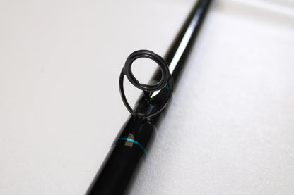 Close-up of a St. Croix Premier Musky PM80XHF 8'0" XH used casting rod in mint condition, featuring a black finish with metal guide ring and blue accents. Perfect for those seeking used gear or store credit via our trade-in program.