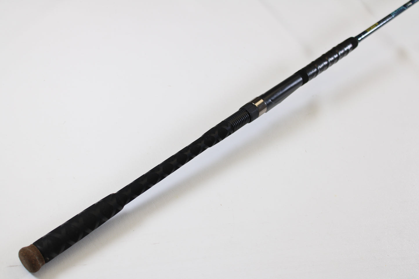 A close-up of a St. Croix Seage SES70MMF 7'0" Medium Used Spinning Rod handle shows a textured grip, metal reel seat, and cork end cap—ideal for upgrading through our Rod and Reel Trade-In Program for store credit.