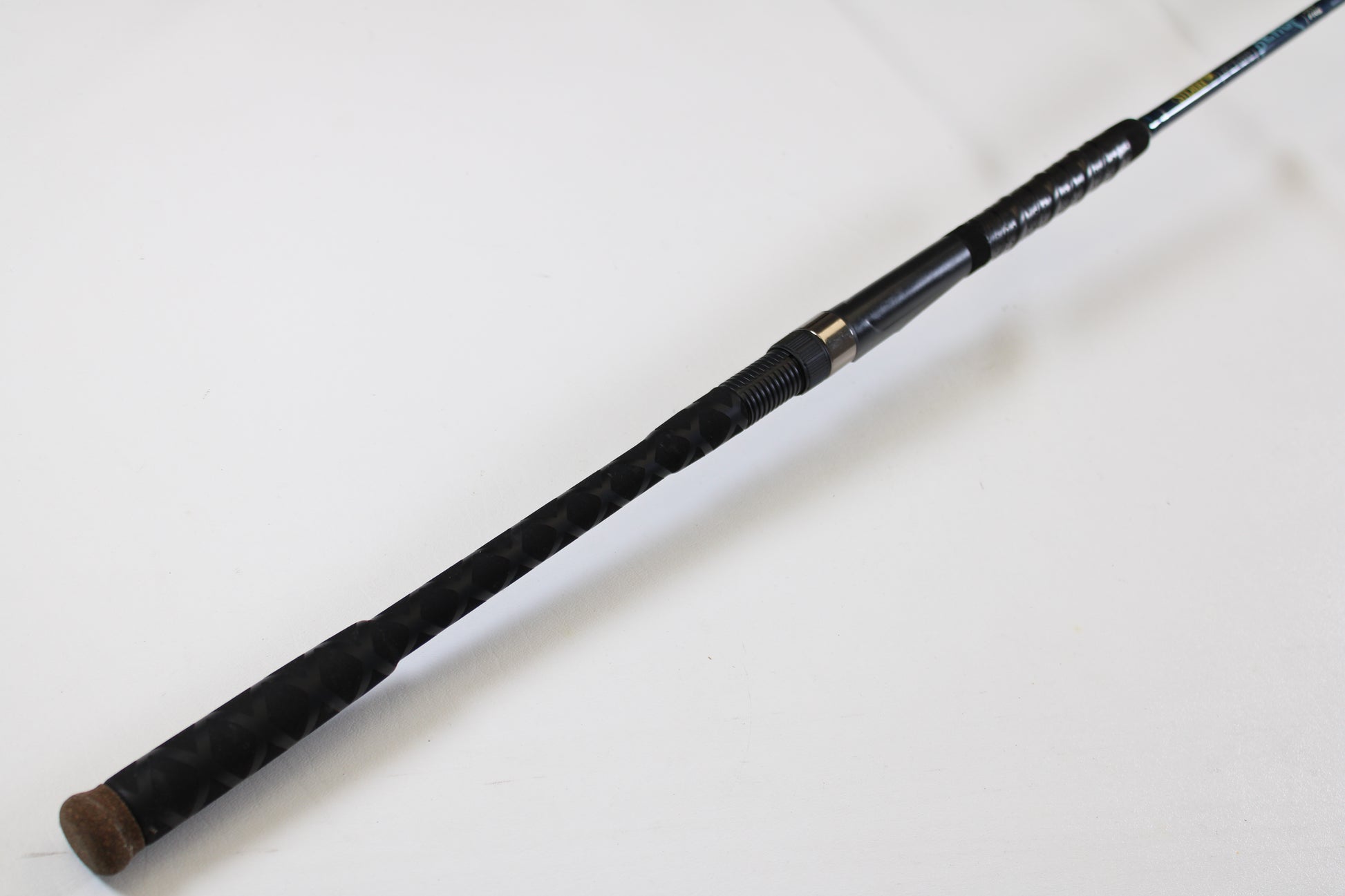 A close-up of a St. Croix Seage SES70MMF 7'0" Medium Used Spinning Rod handle shows a textured grip, metal reel seat, and cork end cap—ideal for upgrading through our Rod and Reel Trade-In Program for store credit.