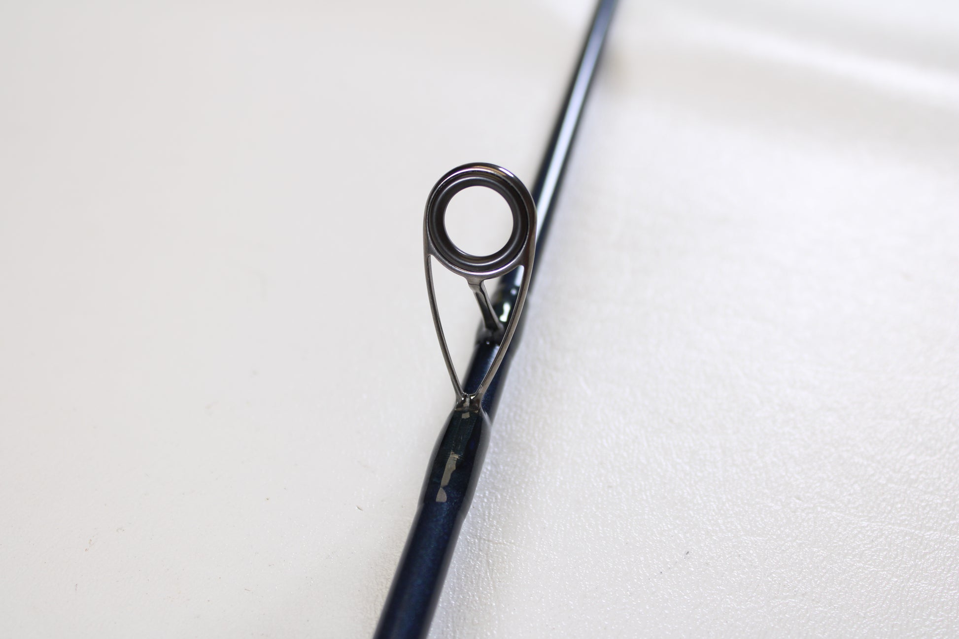 Close-up of a St. Croix Seage SES70MMF 7'0" Medium Used Spinning Rod in mint condition, highlighting the guide ring with its metal eyelet and supports—ideal for upgrading gear through our Trade-In Program. Shown on a plain white background.