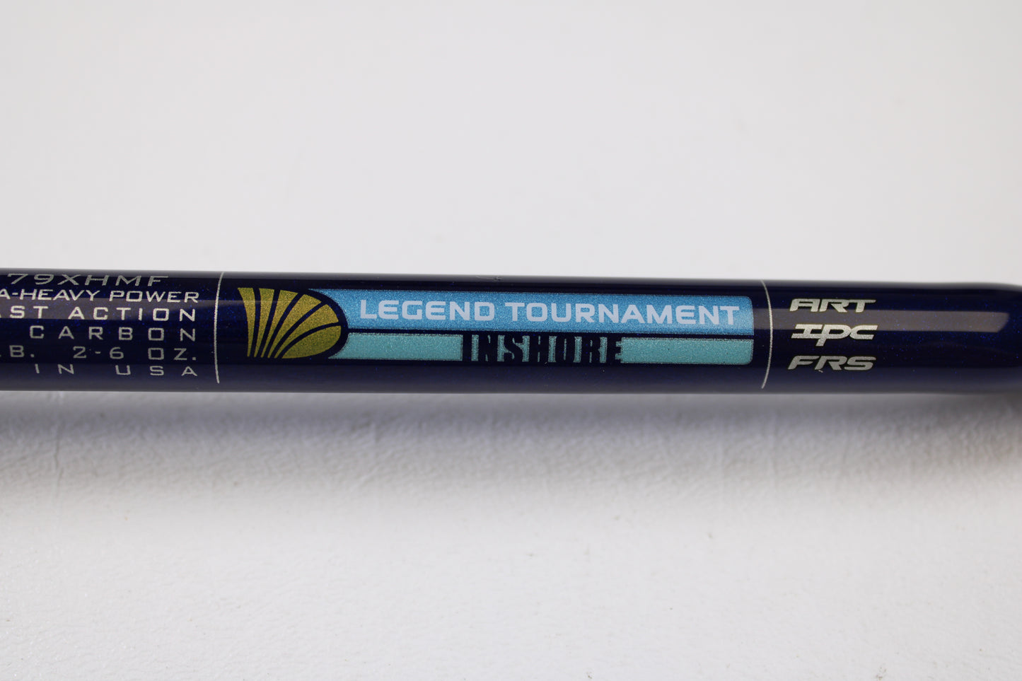 A close-up of a St. Croix Legend Tournament Inshore ITLC79XHMF 7'9" XH used casting rod in mint condition, featuring specs and a gold seashell logo on a blue and black background. Trade in your old gear for store credit with our Rod and Reel Trade-In Program.