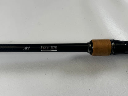 Close-up of a Daiwa BLXSG721HFB 7'2" Heavy casting rod handle with thick cork seal, black shaft, and "BLX" engraving. Ideal for upgrading through our Rod and Reel Trade-In Program. Shown against a smooth, light-colored background.