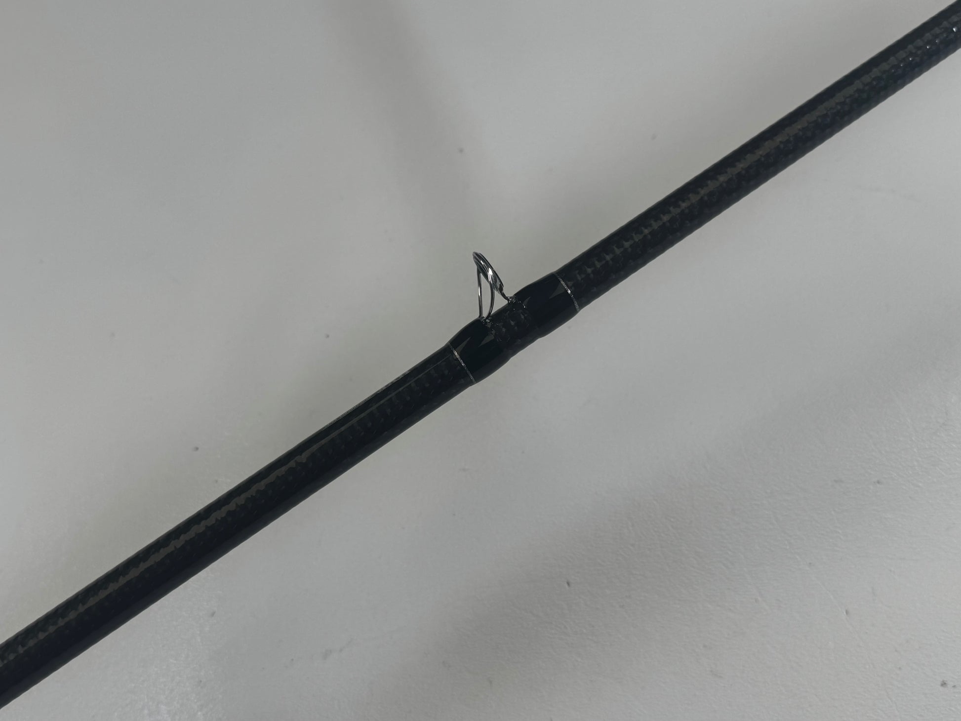 A Daiwa BLXSG721HFB 7'2" Heavy casting rod in excellent condition with a thick cork seal is showcased against a light gray background. Its slightly reflective texture and sleek finish make it perfect for the Rod and Reel Trade-In Program.