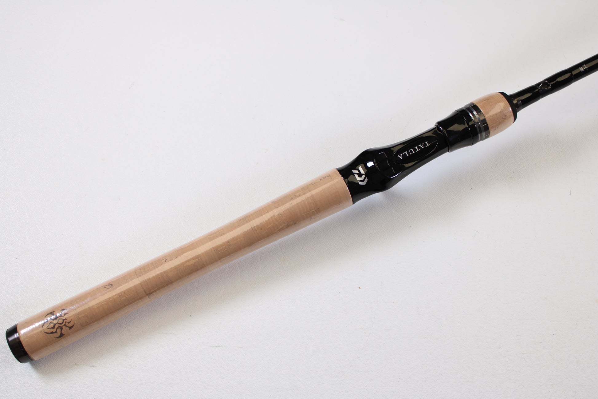 A close-up of a Daiwa Tatula TTU711HFB Used Casting Rod handle with a sleek grip and reel seat, branded “Daiwa.” Highlight your used gear for our rod and reel trade-in program—photographed on a clean white background.