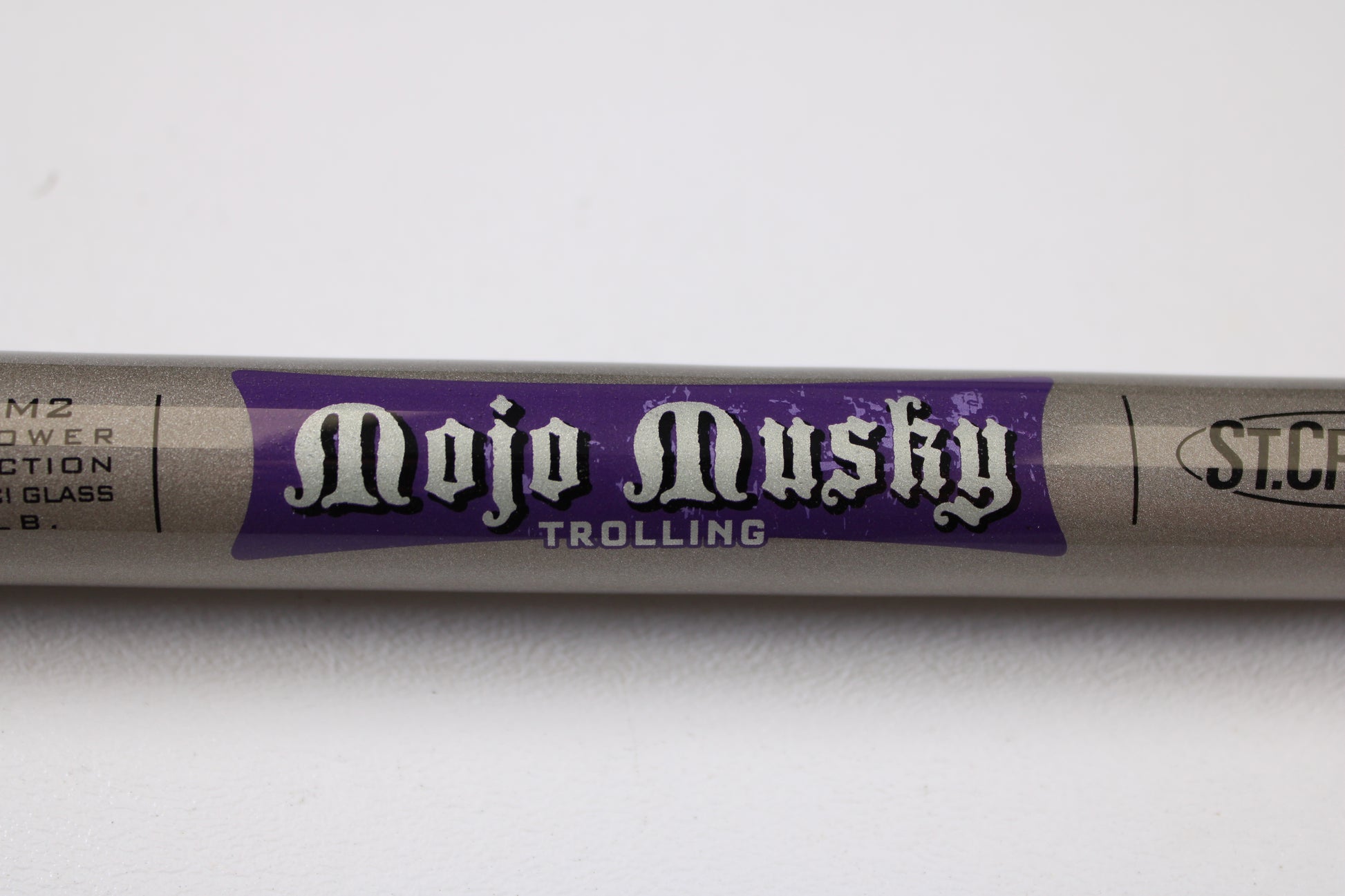 A close-up of the St. Croix Mojo Musky Trolling MMT90HM2 9'0" Heavy Used Casting Rod in mint condition, ideal for anglers seeking quality gear or trading in with our Rod and Reel Trade-In Program. The rod is shown resting on a white surface.
