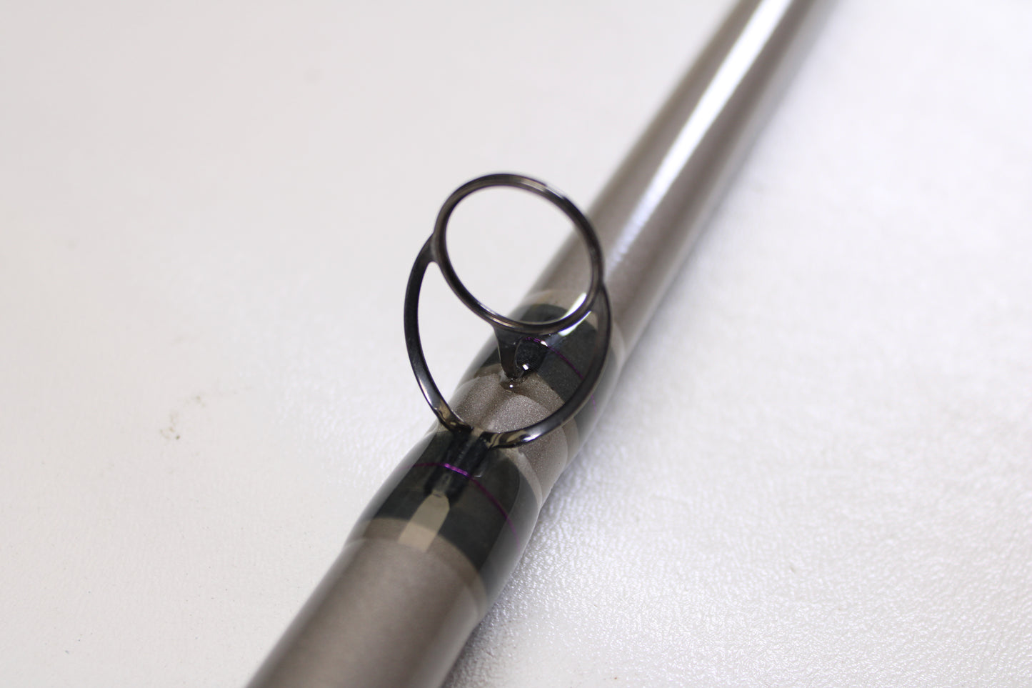 Close-up of a St. Croix Mojo Musky Trolling MMT90HM2 9'0" Heavy used casting rod guide ring, wrapped in metallic thread—ideal for anglers upgrading gear with our Rod and Reel Trade-In Program for store credit. Mint condition!.