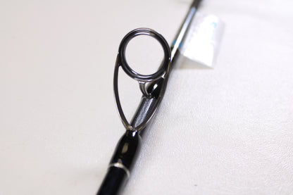 Close-up of a Shimano Terez BW TZBWS72MSBA 7'2" Medium Used Casting Rod in mint condition, highlighting the guide ring on its sleek black finish against a white background. Great option if you're considering an upgrade with our trade-in program.