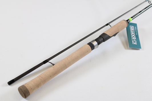 A G. Loomis E6X Walleye 782 2S WUR 6’6” Medium 2 Piece Used Spinning Rod in mint condition, featuring a cork handle and black reel seat, is displayed on a white surface with a blue and white G. Loomis tag near the handle.