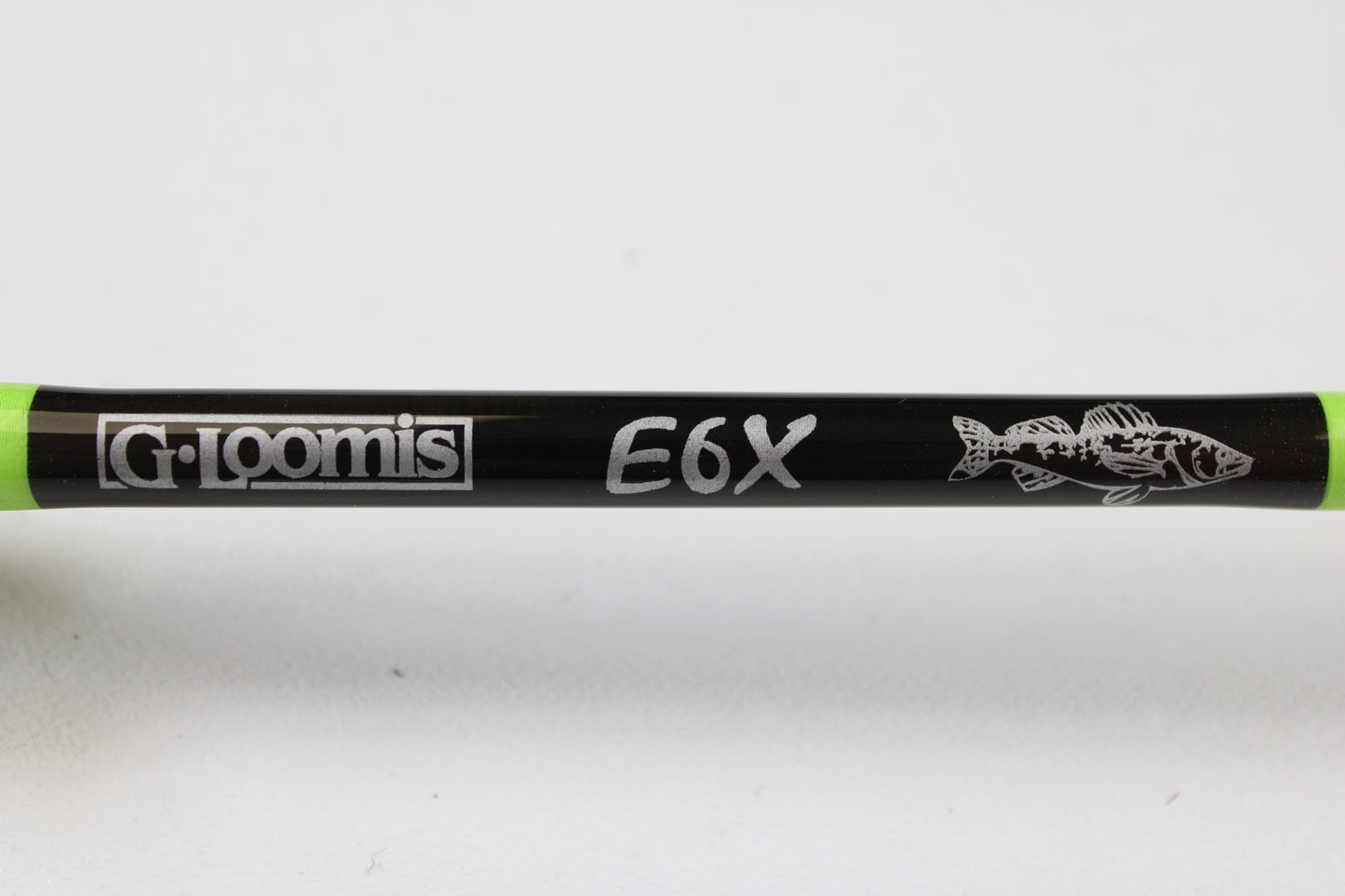 Close-up of a G. Loomis E6X Walleye 782S WUR 6’6” Medium Used Spinning Rod in mint condition, showing the logo, "E6X" text, fish design, and green accents—ideal for our rod and reel trade-in program for store credit.