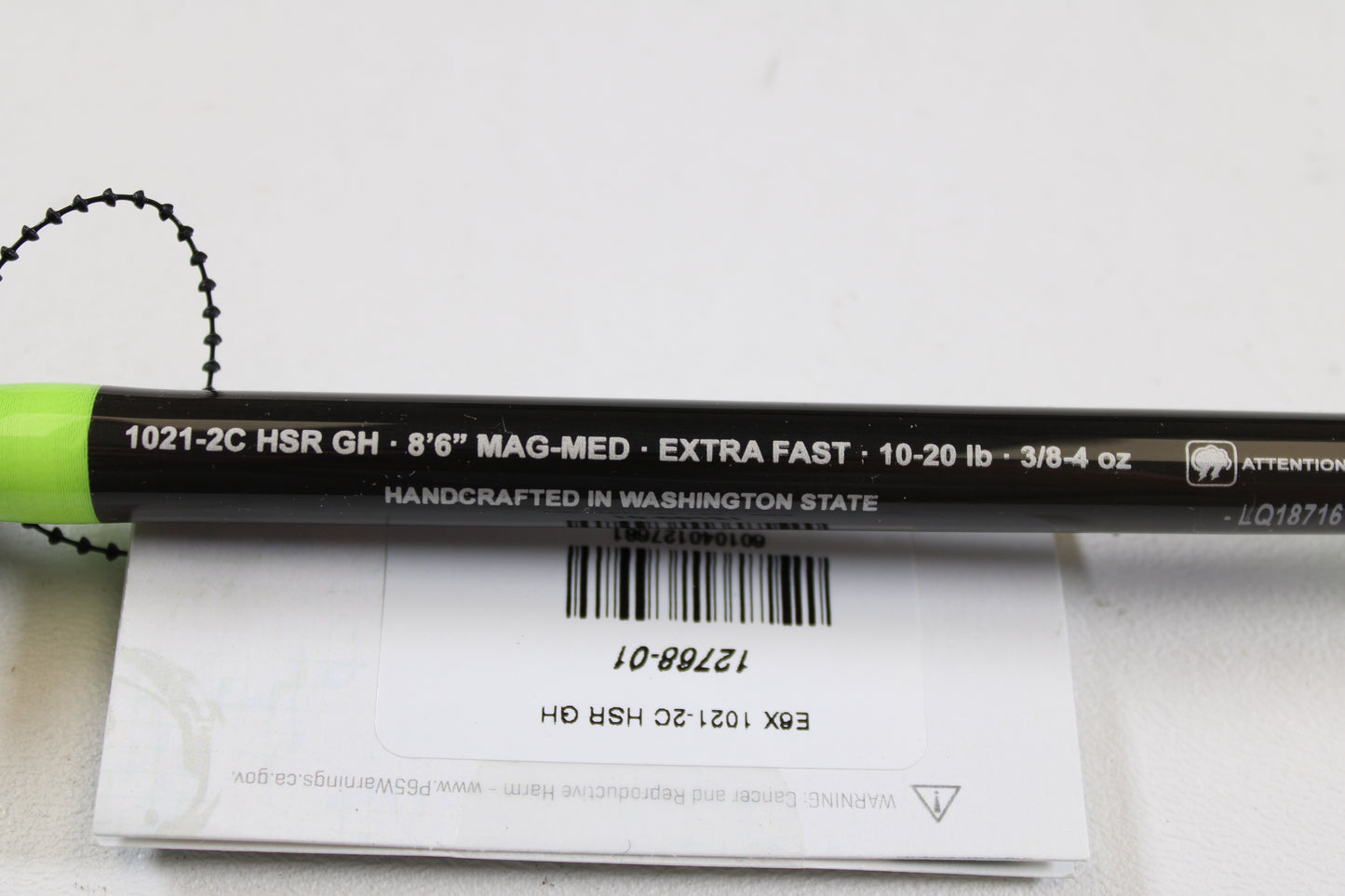 A close-up of the G. Loomis E6X Steelhead 1021-2C HSR GH Used Casting Rod—mint condition, black with green accents. Specs: 8’6” Mag-Med, Extra Fast, 10-20 lb, 3/8-4 oz. Ask about our rod/reel trade-in for store credit!.