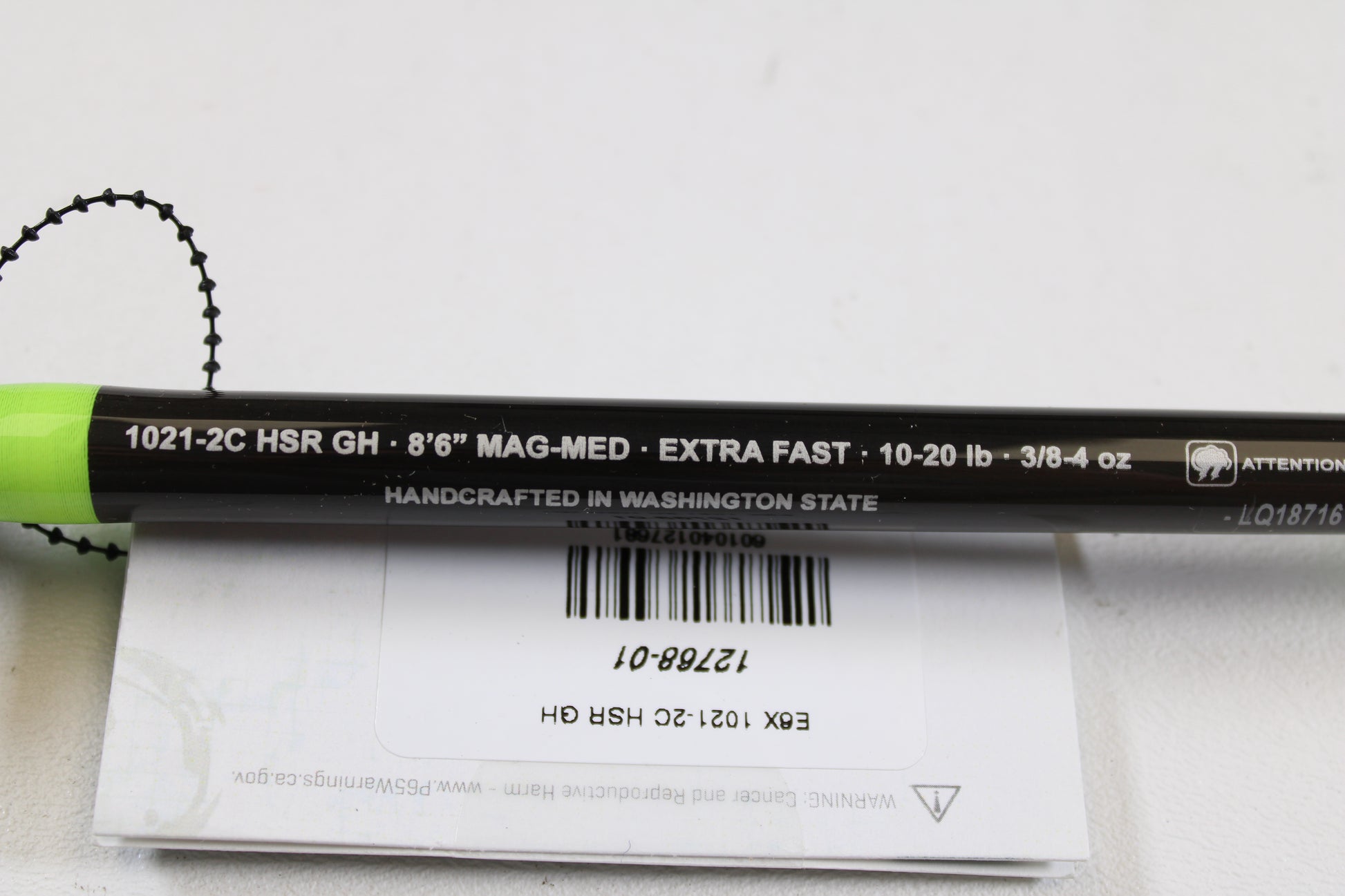 A close-up of the G. Loomis E6X Steelhead 1021-2C HSR GH Used Casting Rod—mint condition, black with green accents. Specs: 8’6” Mag-Med, Extra Fast, 10-20 lb, 3/8-4 oz. Ask about our rod/reel trade-in for store credit!.