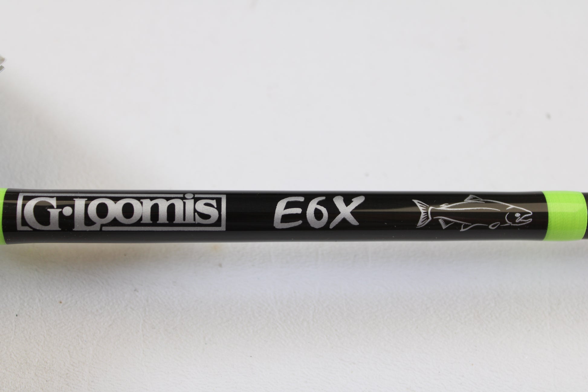 Close-up of a mint condition G. Loomis E6X Steelhead 1021-2C HSR GH Used Casting Rod with bold white logos and neon green accents—ideal for anglers seeking quality used gear or store credit via our rod and reel trade-in.