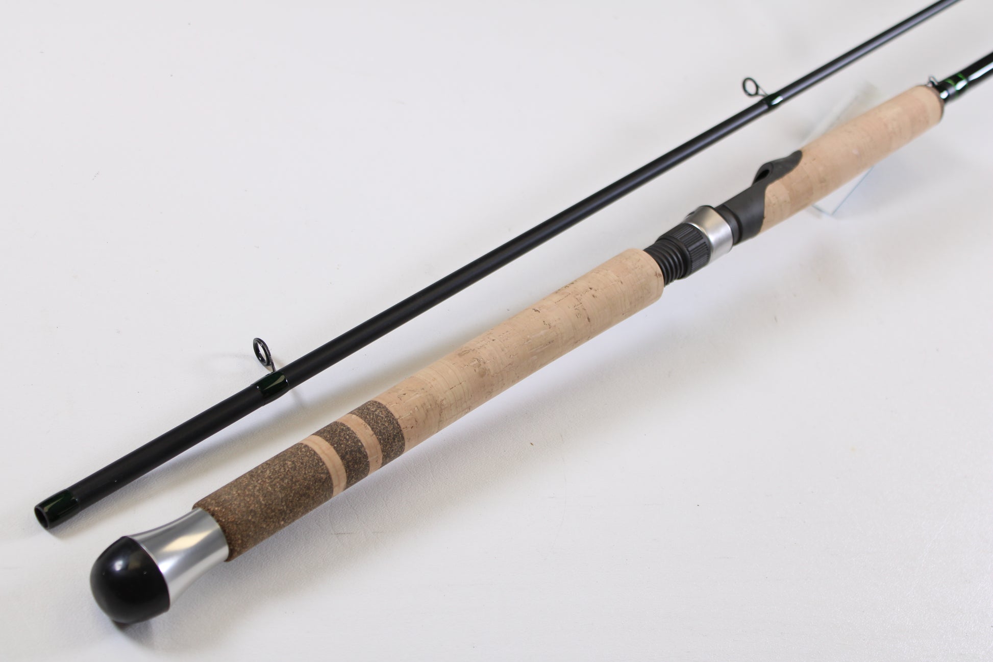 A close-up of the G. Loomis IMX-PRO Steelhead Centerpin 12'0" Heavy 2 Piece Used Spinning Rod in mint condition, disassembled to show the cork handle and metal reel seat—ideal for upgrading your gear or trading in with our program.