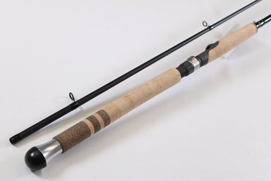 A close-up of the G. Loomis IMX-PRO Steelhead Centerpin 12'0" Heavy 2 Piece Used Spinning Rod in mint condition, disassembled to show the cork handle and metal reel seat—ideal for upgrading your gear or trading in with our program.