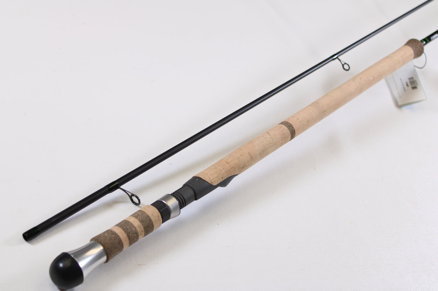 A G. Loomis IMX-PRO Steelhead Centerpin 11'4" Medium Light 2 Piece Used Spinning Rod in mint condition rests on a white surface—ideal for upgrading via our Rod and Reel Trade-In Program or earning store credit for your used gear.