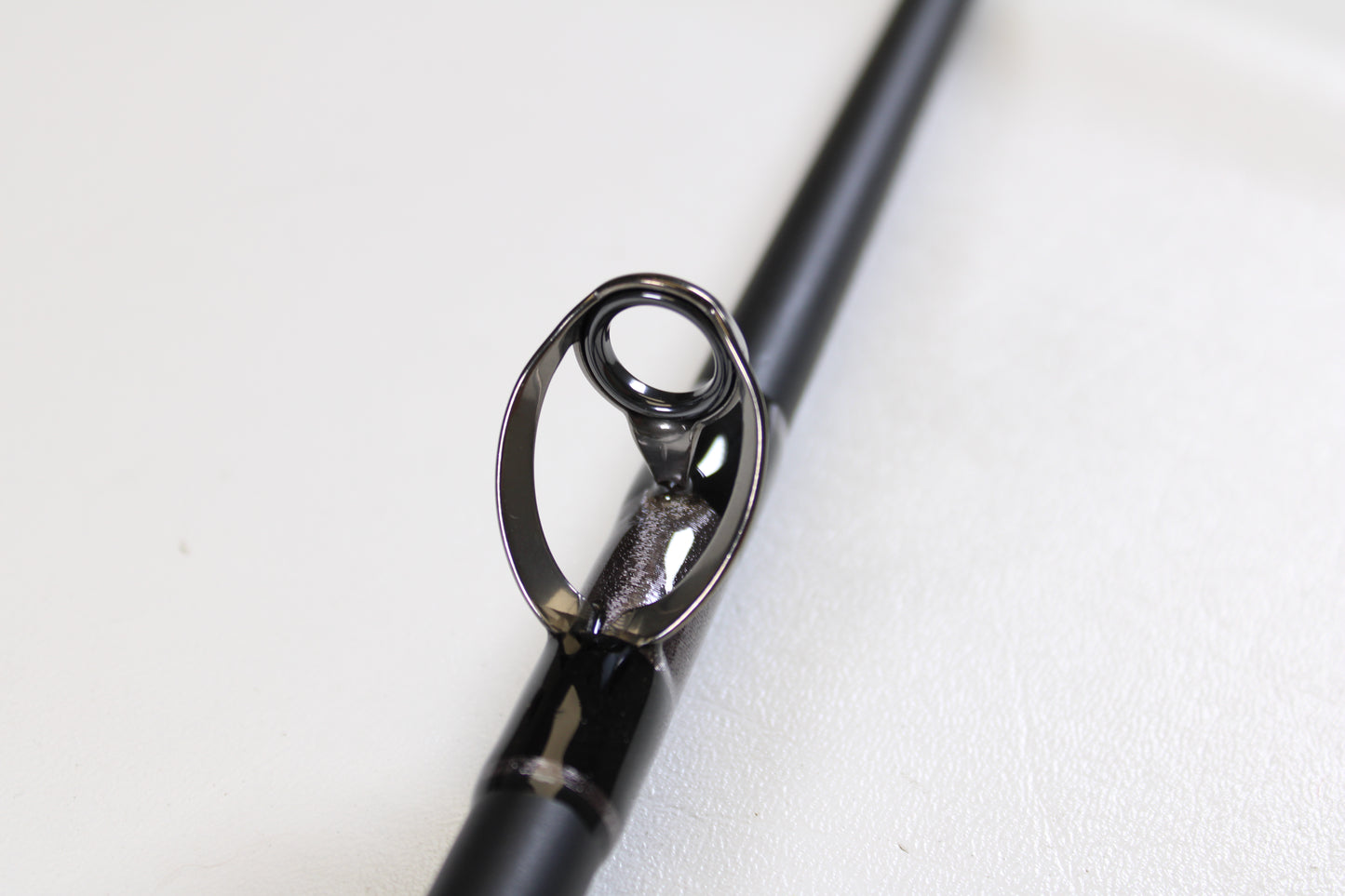 Close-up of the G. Loomis IMX-PRO Offshore 90-40 7'6" Medium Heavy Used Casting Rod in mint condition, highlighting its metal guide ring—ideal for anglers seeking top-quality pre-owned G. Loomis gear.