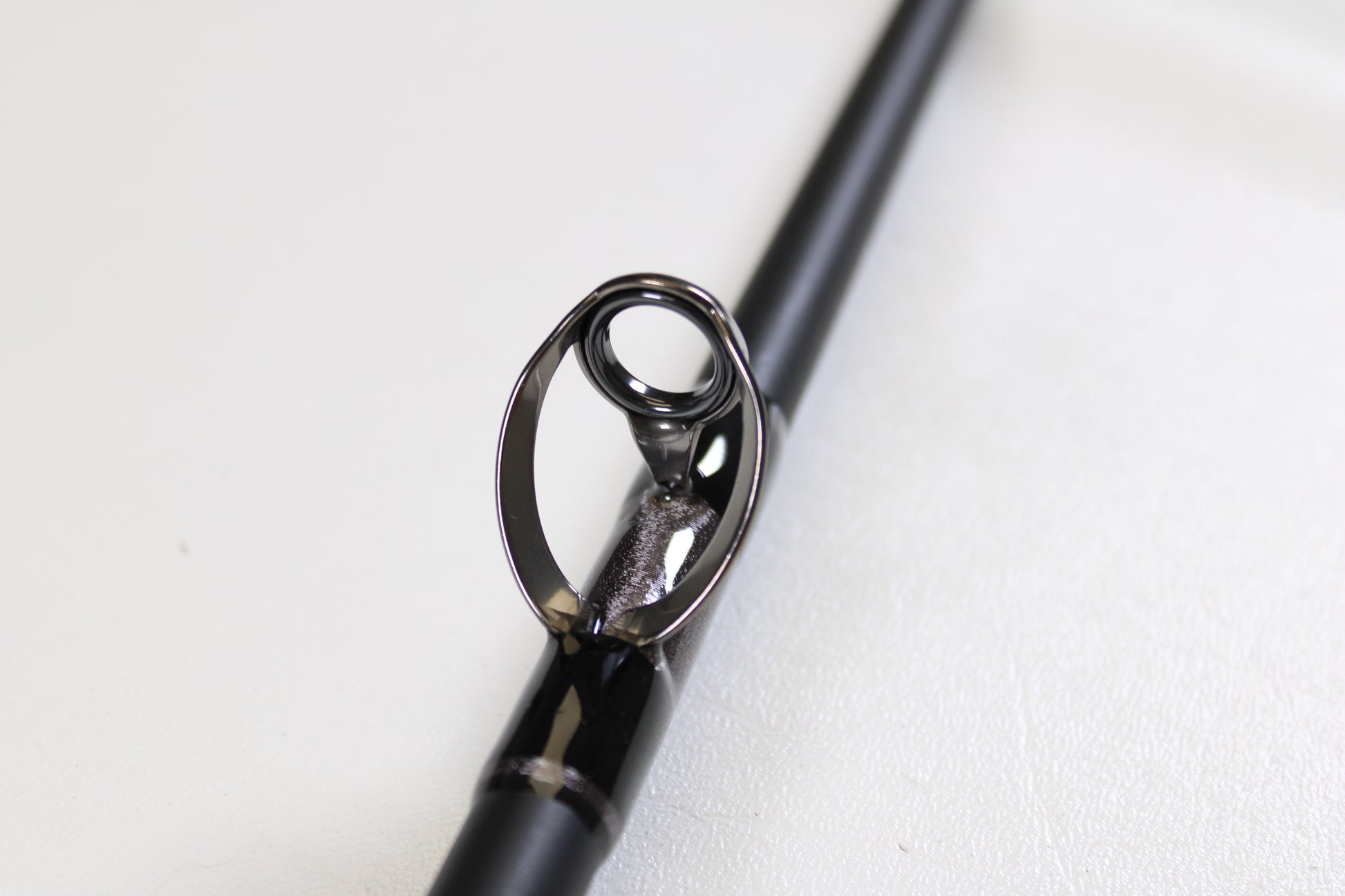 Close-up of the G. Loomis IMX-PRO Offshore 90-40 7'6" Medium Heavy Used Casting Rod in mint condition, highlighting its metal guide ring—ideal for anglers seeking top-quality pre-owned G. Loomis gear.