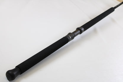 A close-up of the G. Loomis IMX-PRO Offshore 96-40 8'0" Medium Heavy Used Casting Rod, in mint condition, displays its black foam grip and reel seat—great for those interested in our rod and reel trade-in program for store credit.