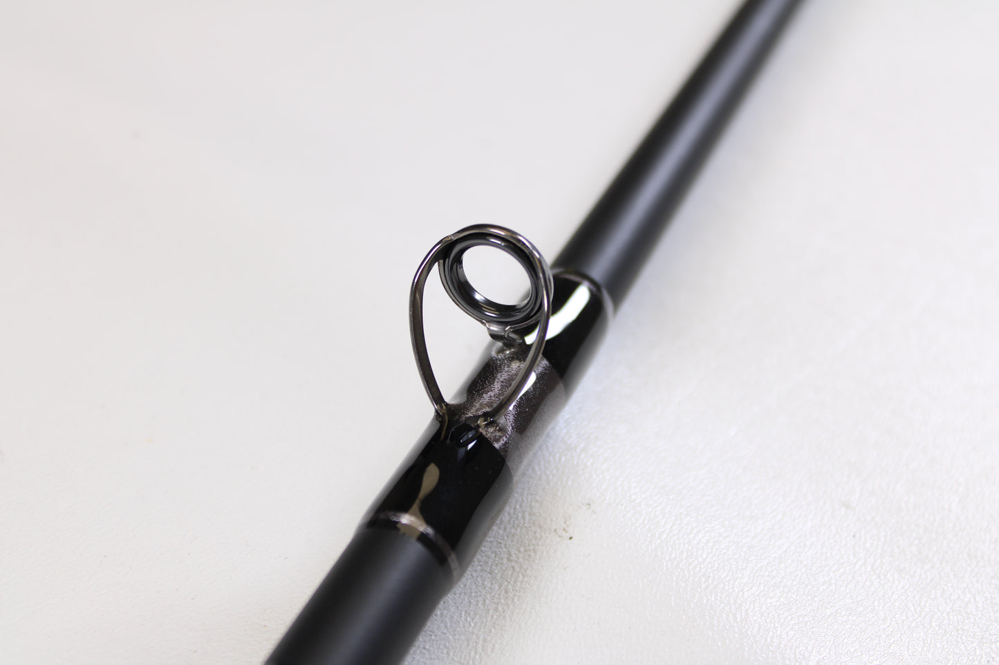 Close-up of the G. Loomis IMX-PRO Offshore 96-20 8'0" Medium Light Used Casting Rod in mint condition, highlighting a metal line guide—an excellent option available through our Rod and Reel Trade-In Program.