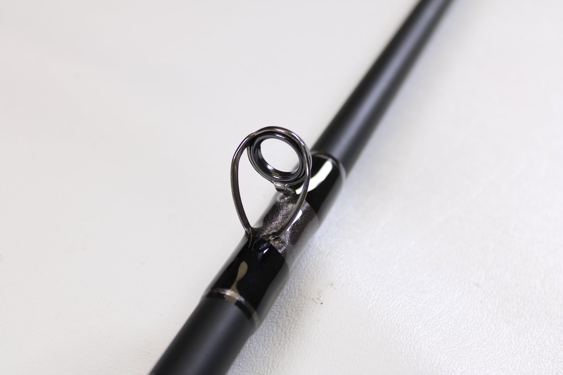 Close-up of the G. Loomis IMX-PRO Offshore 96-20 8'0" Medium Light Used Casting Rod in mint condition, highlighting a metal line guide—an excellent option available through our Rod and Reel Trade-In Program.