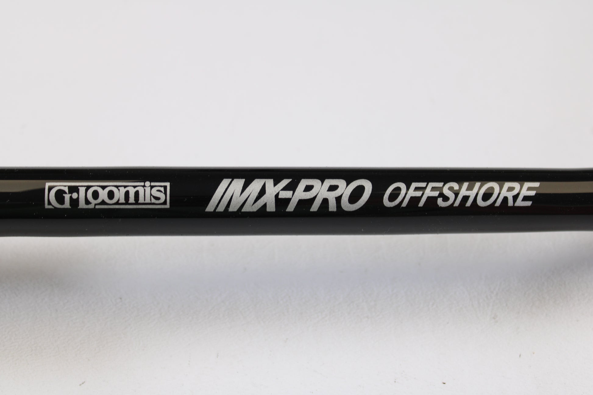 Close-up of a G. Loomis IMX-PRO Offshore 90-50 7'6" Heavy Used Casting Rod in mint condition—ideal for anglers interested in used gear or taking advantage of our Rod and Reel Trade-In Program for store credit.