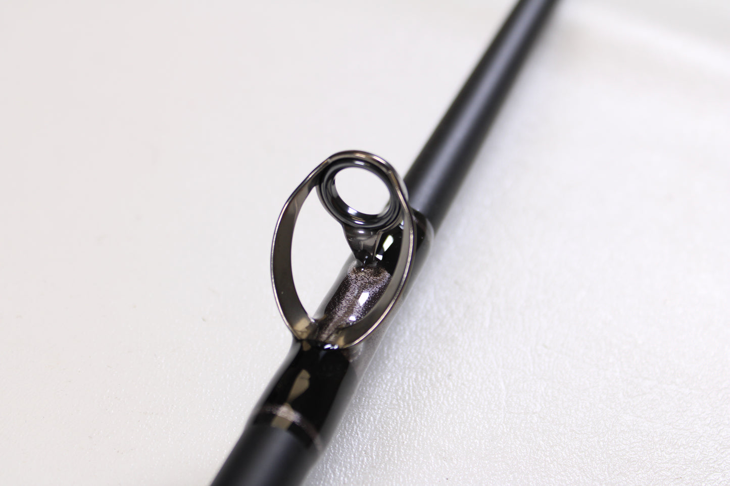 Close-up of a G. Loomis IMX-PRO Offshore 90-50 7'6" Heavy Used Casting Rod guide, displaying the ring and frame detail—ideal for anglers looking to trade up through our Rod and Reel Trade-In Program for store credit.