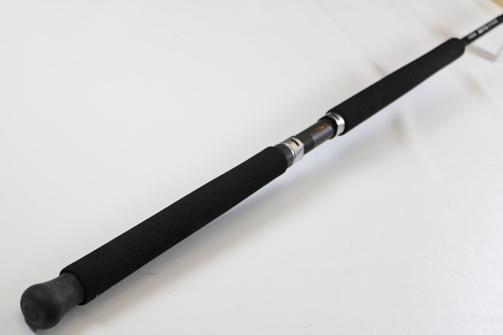 A close-up of the G. Loomis IMX-PRO Offshore 96-30 8'0" Medium Used Casting Rod (Mint Condition) handle against a white background—ideal for those looking to trade in used G. Loomis gear for store credit through our Trade-In Program.