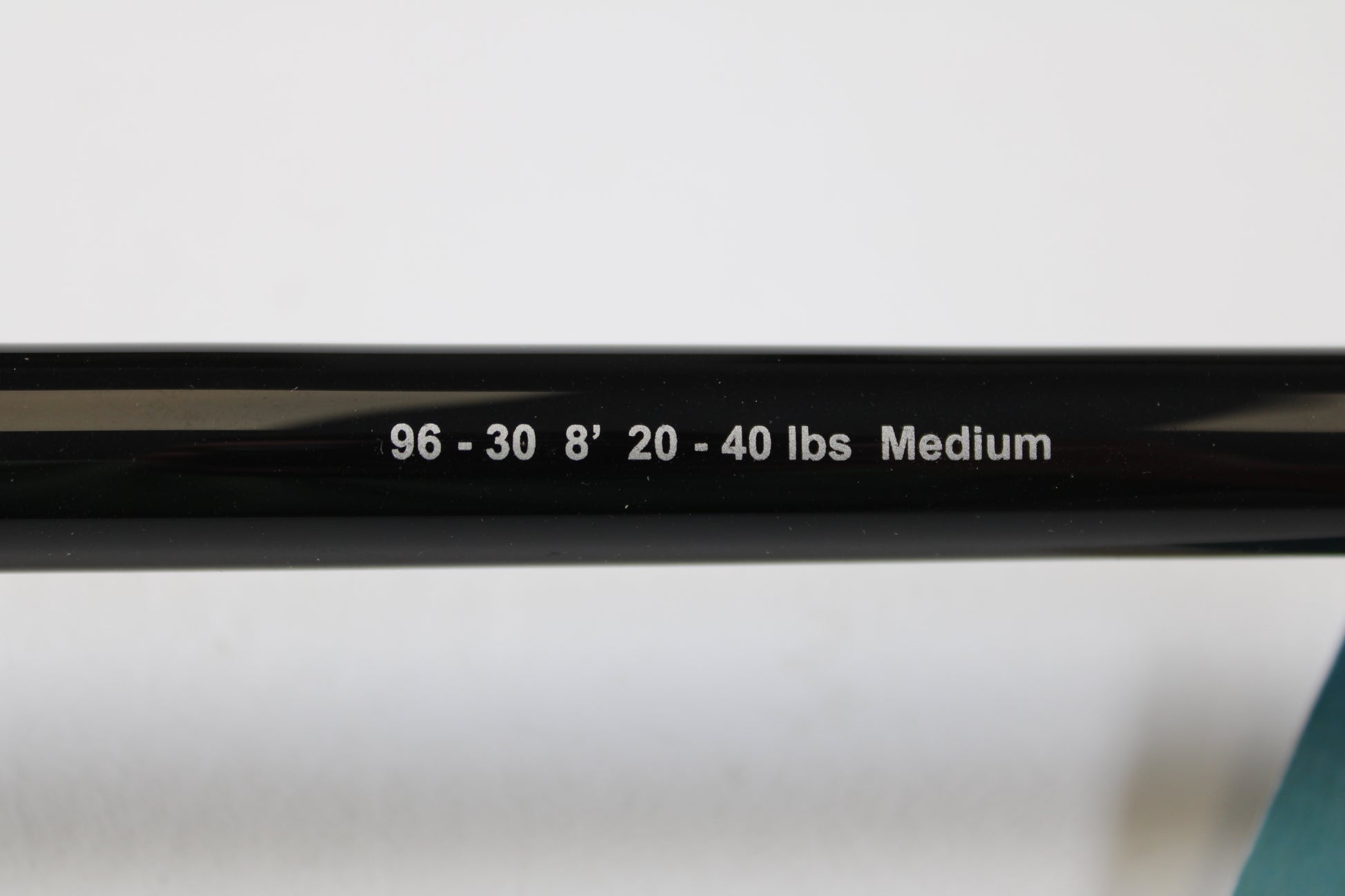 Close-up of a G. Loomis IMX-PRO Offshore 96-30 8'0" Medium Used Casting Rod (Mint Condition) shows its white printed specs—great for our Rod and Reel Trade-In Program if you’re ready to upgrade your used gear.