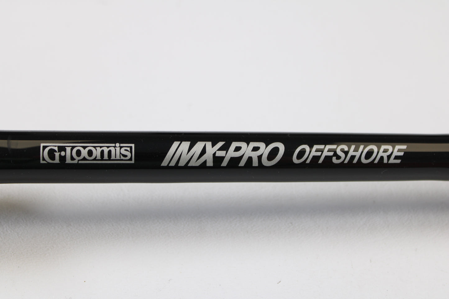 Close-up of a G. Loomis IMX-PRO Offshore 90-80 7'6" XXH Used Casting Rod in mint condition against a white background—eligible for our Rod and Reel Trade-In Program to earn store credit on used gear.
