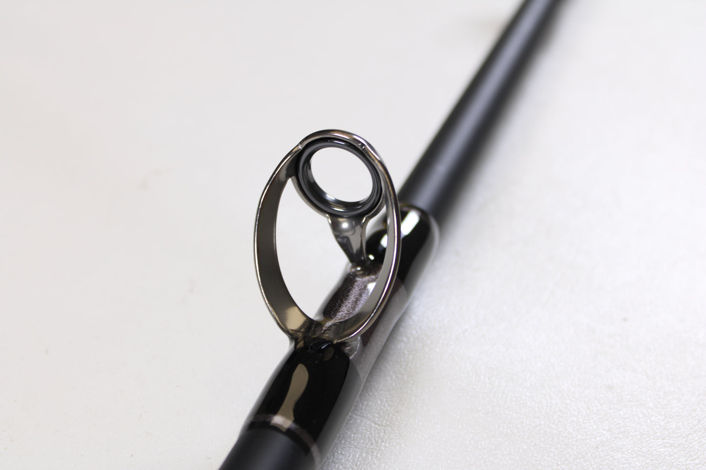 Close-up of the G. Loomis IMX-PRO Offshore 90-80 7'6" XXH—Used Casting Rod in mint condition, highlighting its glossy guide ring. Upgrade with our Rod and Reel Trade-In Program and get store credit for your used G. Loomis gear.