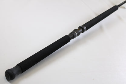 A close-up of the G. Loomis IMX-PRO Offshore 90-60 7'6" XH used casting rod in mint condition, featuring black foam grips and a metal reel seat, ideal for anglers considering pre-owned gear or a trade-in.