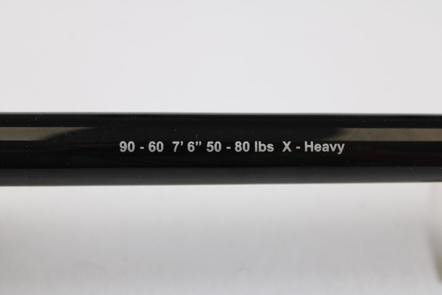 A close-up of a G. Loomis IMX-PRO Offshore 90-60 7'6" XH Used Casting Rod in mint condition, featuring white text on a black finish—ideal for trading in or earning store credit on used G. Loomis gear.